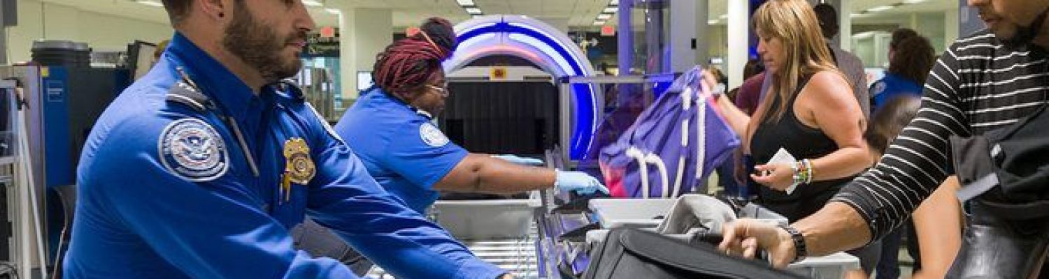 MIAMI, FLORIDA - MAY 21: Transportation Security Administration (TSA) agents help travelers place their bags through the 3-D scanner at the Miami International Airport on May 21, 2019 in Miami, Florida. TSA has begun using the new 3-D computed tomography (CT) scanner in a checkpoint lane to detect explosives and other prohibited items that may be inside carry-on bags.  (Photo by Joe Raedle/Getty Images)